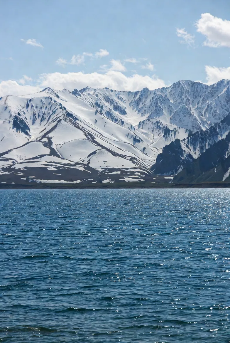 푸른 이식쿨 호수와 그 뒤로 펼쳐진 설산의 웅장한 모습