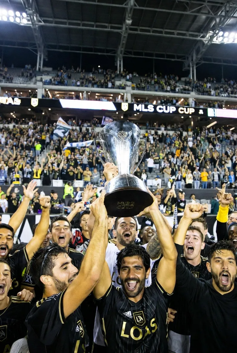 2022 MLS 컵 우승 순간, 카를로스 벨라가 트로피를 들고 팬들을 향해 환호하는 감동적인 장면